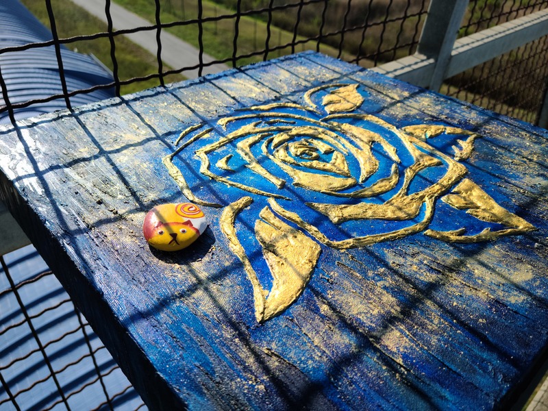 VIRGOのレーザー光源のアームの上で輝くマッジーフランチェスコの作品「Rosa Blu」青いバラ